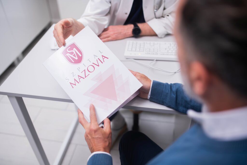 Mężczyzna trzymający teczkę z badaniami